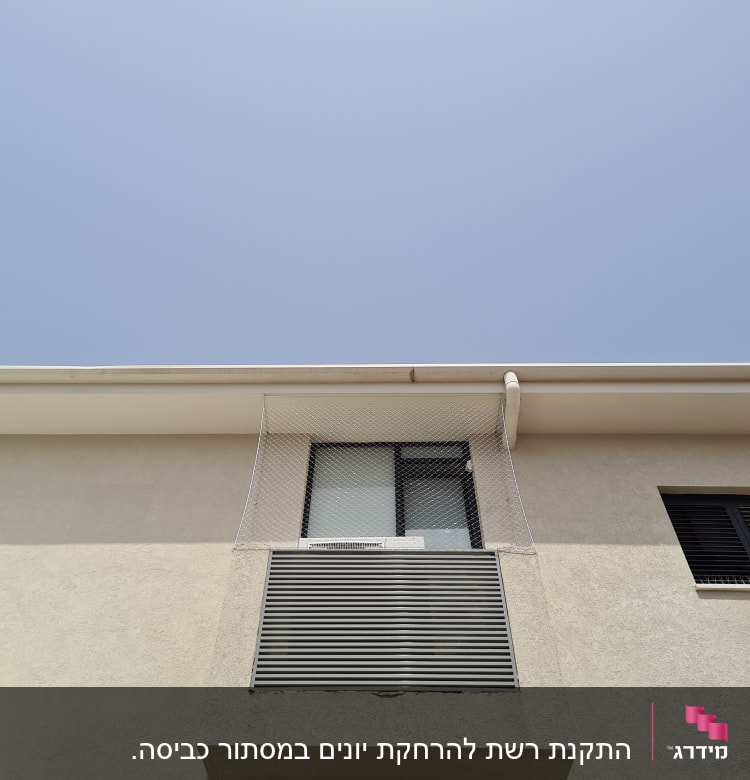 רשת הגנה מותקנת על חלון למניעת כניסת יונים